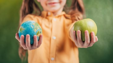 Earth Day - Child holding apple and globe